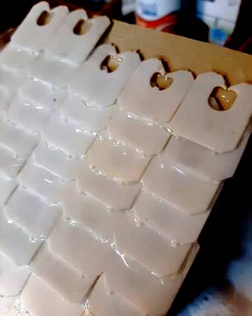 gluing rows of bread ties on the roof of a bird house